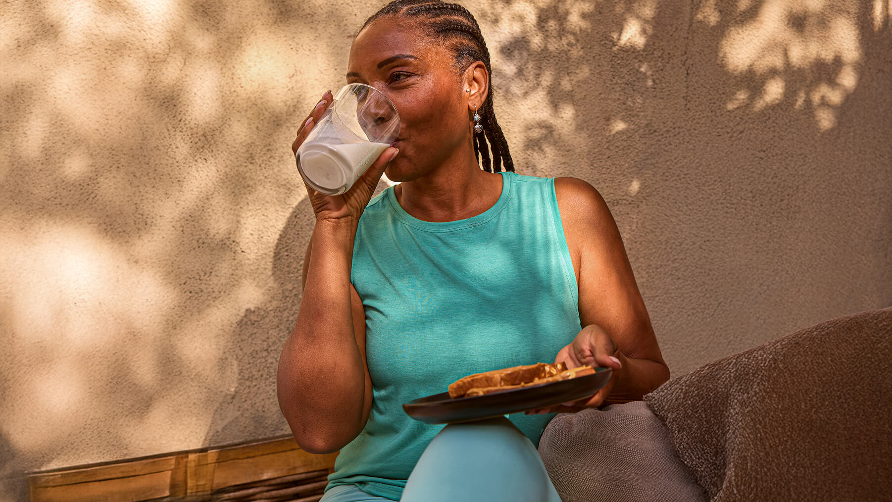 A female with a bright smile, holding a bottle of chocolate milk.